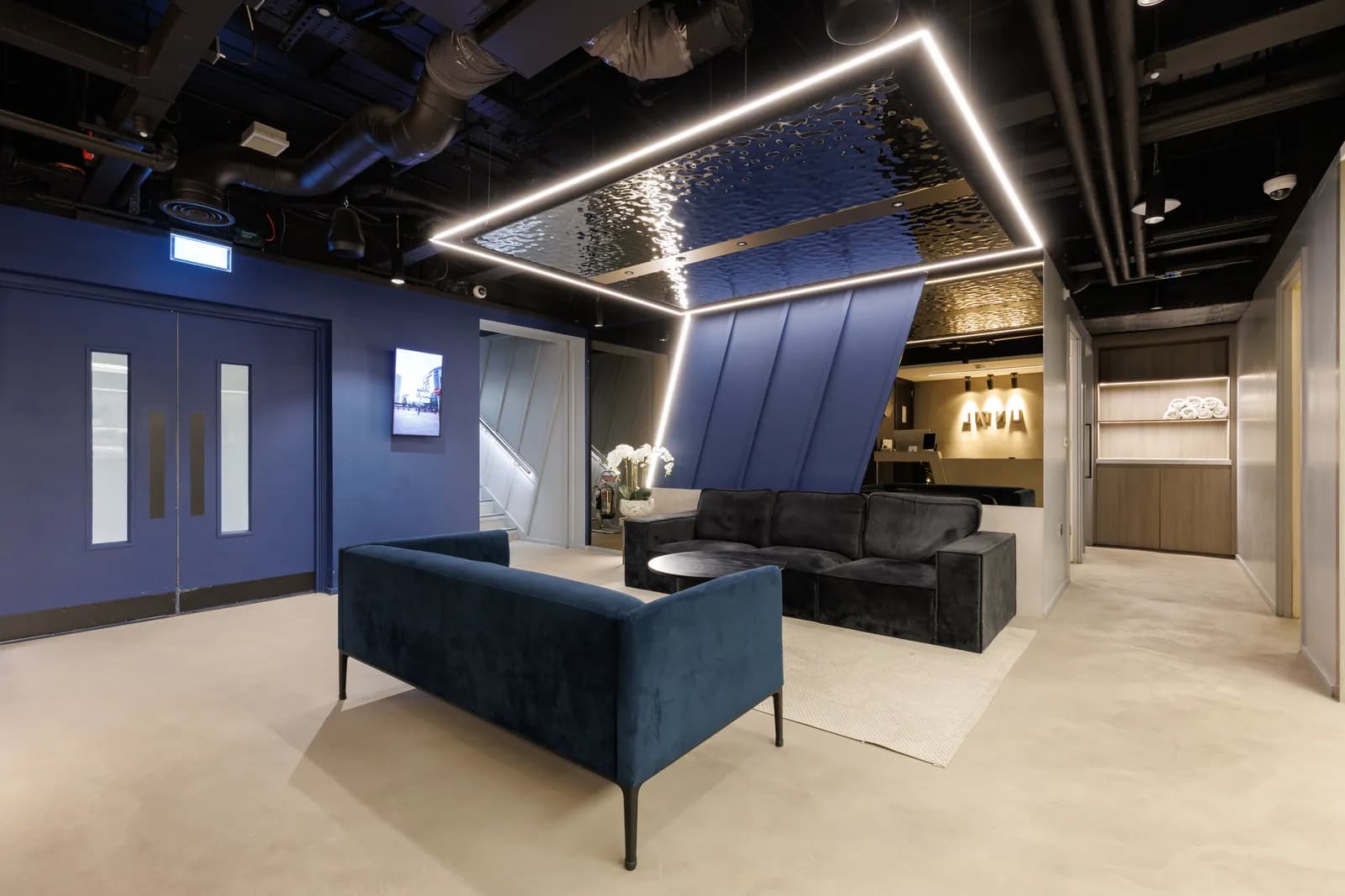 UNTIL Liverpool Street lounge and reception with velvet sofa seating beneath a mirrored ceiling feature.